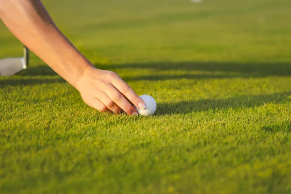 Mão feminina colocando bola de golfe no tee — Fotografia de Stock