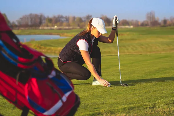 Junge schöne Frau trainiert im Herbst Golf lizenzfreie Stockfotos