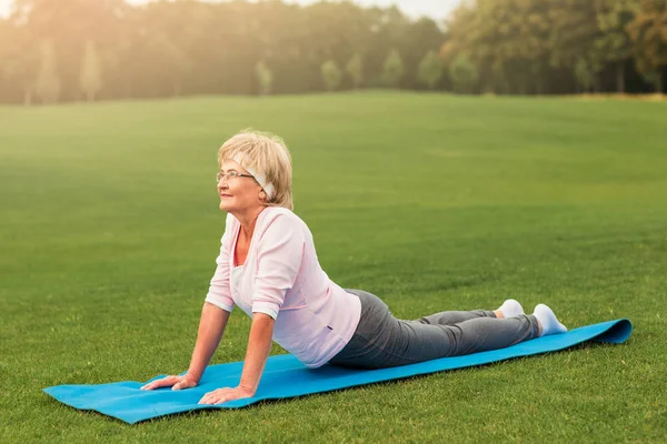 Mujer madura practicando yoga en el parque —  Fotos de Stock