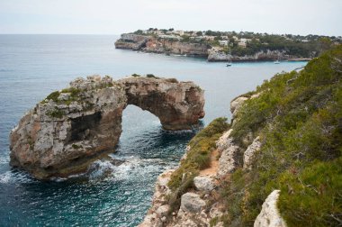 Mallorca 'da Es Pontas, Akdeniz' e demir atmış bir tekne. Santanyi yakınlarında yatı ve kaya kemeri olan Mayorka Gündoğumu. Mayorka Cala Llombards Santanyi plajı Mallorca