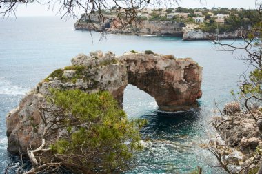 Mallorca 'da Es Pontas, Akdeniz' e demir atmış bir tekne. Santanyi yakınlarında yatı ve kaya kemeri olan Mayorka Gündoğumu. Mayorka Cala Llombards Santanyi plajı Mallorca