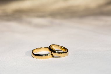 Two golden wedding rings on the white fabric