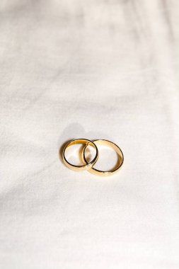 Two golden wedding rings on the white fabric
