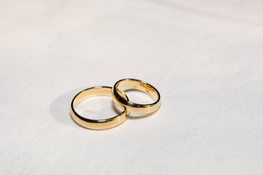 Two golden wedding rings on the white fabric
