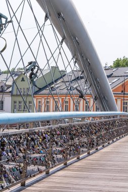 Krakow, Polonya - 27 Temmuz 2019 - Kladka Bernatka Köprüsü Vistula nehri üzerinde korkulukta asma kilitlerle (aşk sembolü)