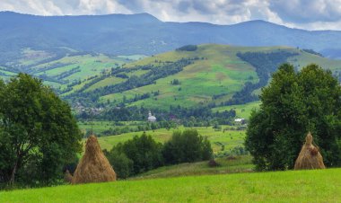 Samanlığı olan güzel bir yaz manzarası. Açık görüş. Yaz perisi. Mavi gökyüzü ve yeşil çimenler. Tepeler ve dağlar. sanat kırsal alan. Saha ve çimenler. Kırsal kesimde yaz mevsimi. Yeşil tarlalar ve tarlalar. Avrupa. Ukrayna