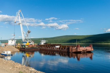 Nehrin arka planında açık bir yaz gününde çalışan kargo vinçleri olan kuzey nehri limanı. Crane, manzara. Nehirdeki kargo limanında vinçler