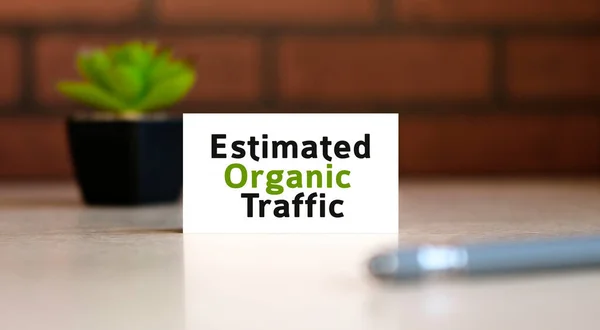 Organic seo traffic - text of business concept on white list and with pen and a black pot with a flower behind