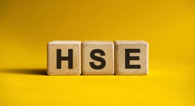 Tahta küplerde sarı arkaplan üzerine HSE metni