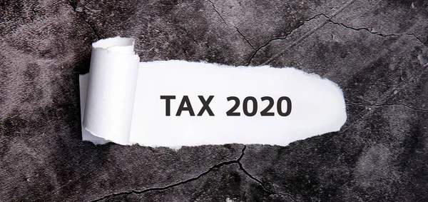 Tax 2020 on a black tablet and with tax forms and calculator