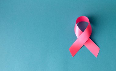 Göğüs kanseri konsepti. Mavi arkaplanda pembe sembolik bant şeridi.