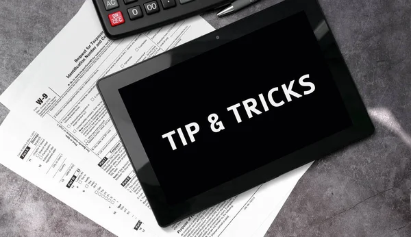 Tip and tricks on a black tablet and with tax forms and calculator