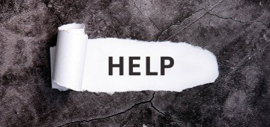 Gri beton bir masada yırtık beyaz kağıt ile yardım