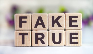 Sahte Gerçek - Lale tomurcuklu çiçek arkaplanındaki tahta küplerle ilgili metin