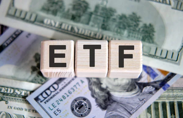 ETF finans sektörü kavramı. Arkaplan olarak tahta küpler ve kağıt dolar banknotları