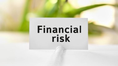 Finansal risk - iş seosu kavramı metni beyaz defter ve yeşil çiçekler üzerinde