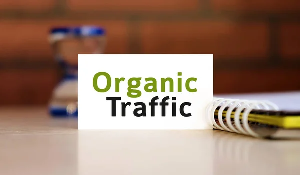 Organic seo traffic - - text n white sheet with notepad and hourglass