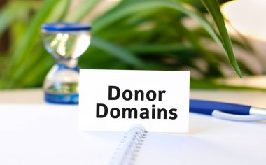 Donör alan adları seo business konsept metin beyaz bir defter ve kum saati, mavi kalem, yeşil çiçekler