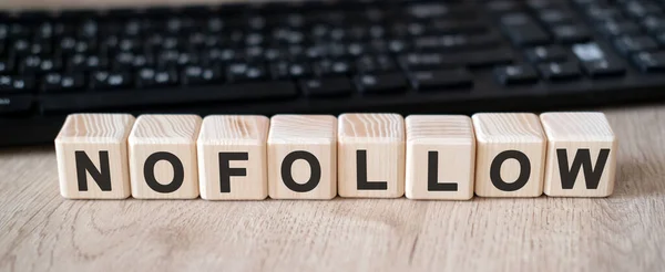 Nofollow linkleri - tahta küpler üzerinde kavram metni ve arkaplan siyah klavye