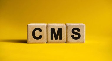 Tahta küplerde sarı arkaplan üzerine CMS metni
