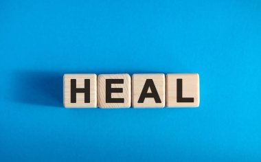 HEAL - ahşap bloklar üzerine metin, tıbbi konsept, mavi arkaplan
