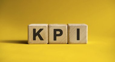 Tahta küplerde sarı arkaplan üzerine KPI metni