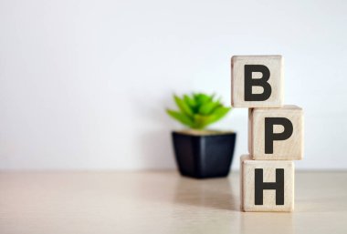 BPH - tahta küplerde, ahşap arka planda metin. Kavanozda çiçek