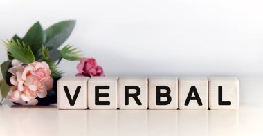 VERBAL - ahşap küplerle ilgili metin, pembe laleler yeşil bitkilerle çiçekli arkaplan
