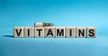 VITAMINS - Küpler hakkında kelime. Mavi arka plandaki hastalık belirtilerini azaltmak için ambulada ilaç.