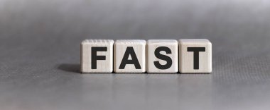 Tek renkli arkaplanda tahta küpler üzerine FAST metni