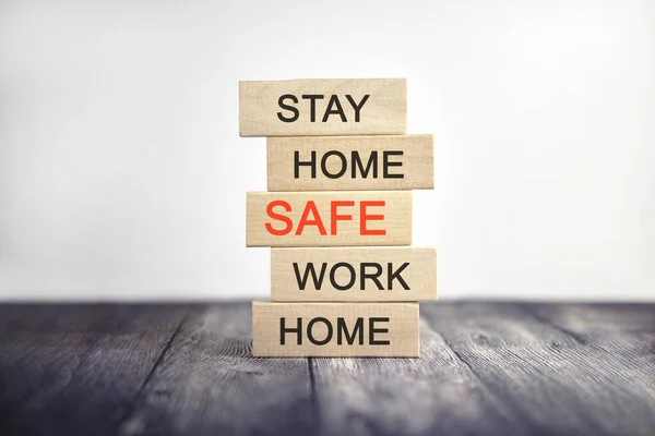 Stay home, be safe and work home - concept text on wooden cubes