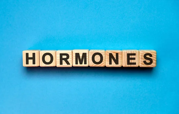 Mavi arka planda Hormonlar kelime küpü. Tıbbi konsept.