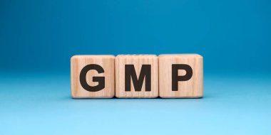 Mavi arka planda GMP kelime küpü. İş konsepti.