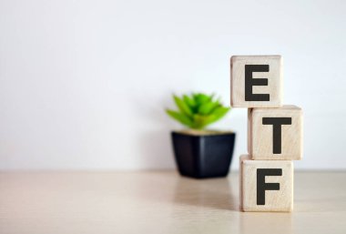 Tahta küplerde, ahşap zeminde ETF metni. Kavanozda çiçek