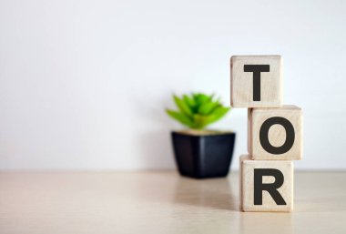 TOR - tahta küplerde, ahşap arka planda metin. Kavanozda çiçek