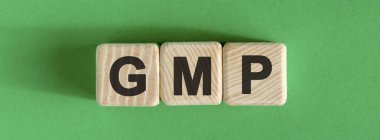 GMP - yeşil arkaplan ile tahta küpler üzerine metin