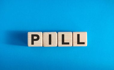 PILL - tahta bloklar üzerine metin, tıbbi konsept, mavi arkaplan