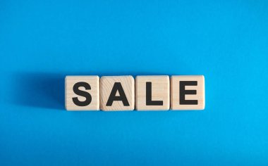 Ahşap bloklar üzerine satış metni, finansal iş konsepti, mavi arkaplan