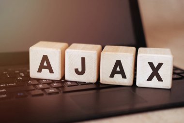 AJAX - Siyah bir dizüstü bilgisayarda tahta bir küp üzerinde programlama metni