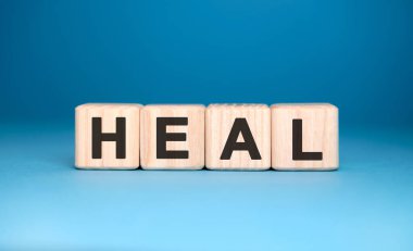 HEAL - ahşap bloklar üzerine metin, tıbbi konsept, mavi arkaplan