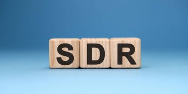 SDR - text concept on wooden cubes with gradient blue background clipart