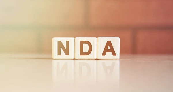 NDA kısaltma kavramı. Parlak ışıklı tahta küplerde metin