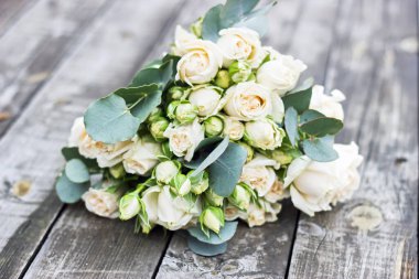 Gelinin düğün buketi ahşap bir masada.