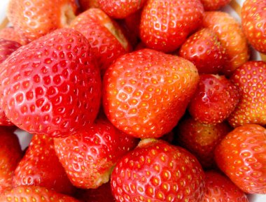 Yeşil çimenlikteki tabakta kırmızı çilekler.