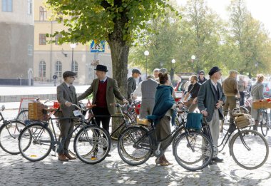 Stockholm - 22 Eylül 2018: 1950'lerde önde gelen eski moda yün elbise giyen insanlar onların retro Tweed olay bisiklet içinde 22 Eylül 2018 Stokholm, İsveç'te Bisikletler