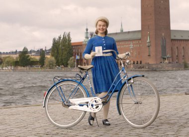 Stockholm - 22 Eylül 2018: retro Bisiklet Stockholm Belediye Binası önünde Tweed olay Bisiklet 22 Eylül 2018 Stokholm, İsveç'te holding eski moda mavi elbiseyle gülümseyen güzel kadın