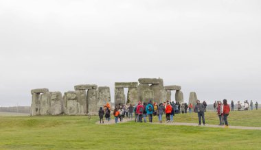 Amesbury, İngiltere - 23 Aralık 2018: Stonehenge taş anıtın izlerken turist bulutlu bir günde inşa geç Neolitik dönemde, MÖ 2500 yıllarında bilinmeyen nedenle. 23 Aralık 2018 Amesbury, İngiltere