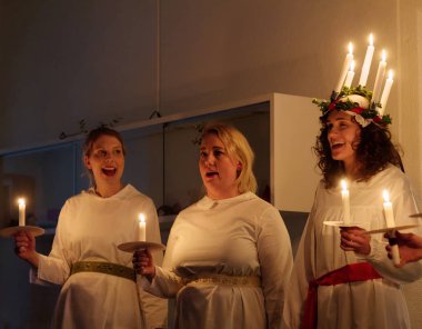 Stockholm, İsveç - 13 Aralık 2018: Lucia parade şarkı söyleyen kız beyaz elbiseler mum tutan ile. Saint Lucia Stokholm, İsveç, İtalya'dan acı 13 Aralık 2018 geleneksel kutlama