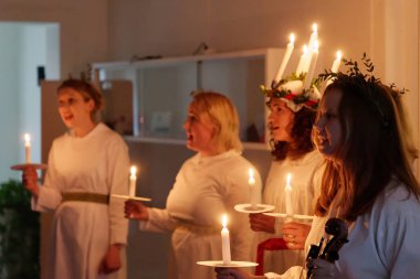 Stockholm, İsveç - 13 Aralık 2018: Lucia parade şarkı söyleyen kız beyaz elbiseler mum tutan ile. Saint Lucia Stokholm, İsveç, İtalya'dan acı 13 Aralık 2018 geleneksel kutlama