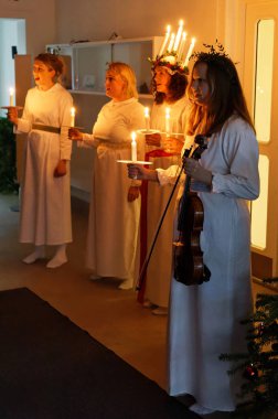 Stockholm, İsveç - 13 Aralık 2018: Lucia parade şarkı söyleyen kız beyaz elbiseler mum tutan ile. Saint Lucia Stokholm, İsveç, İtalya'dan acı 13 Aralık 2018 geleneksel kutlama
